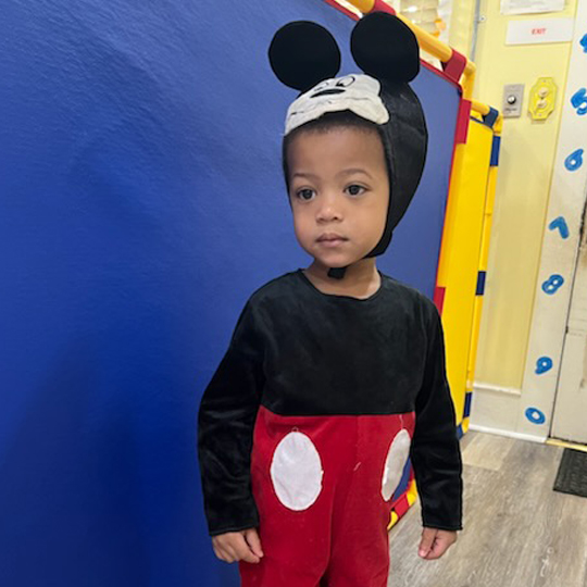 Small child dressed as Mikey Mouse.