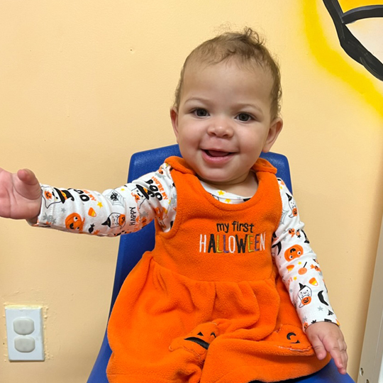 Small child in orange dress.